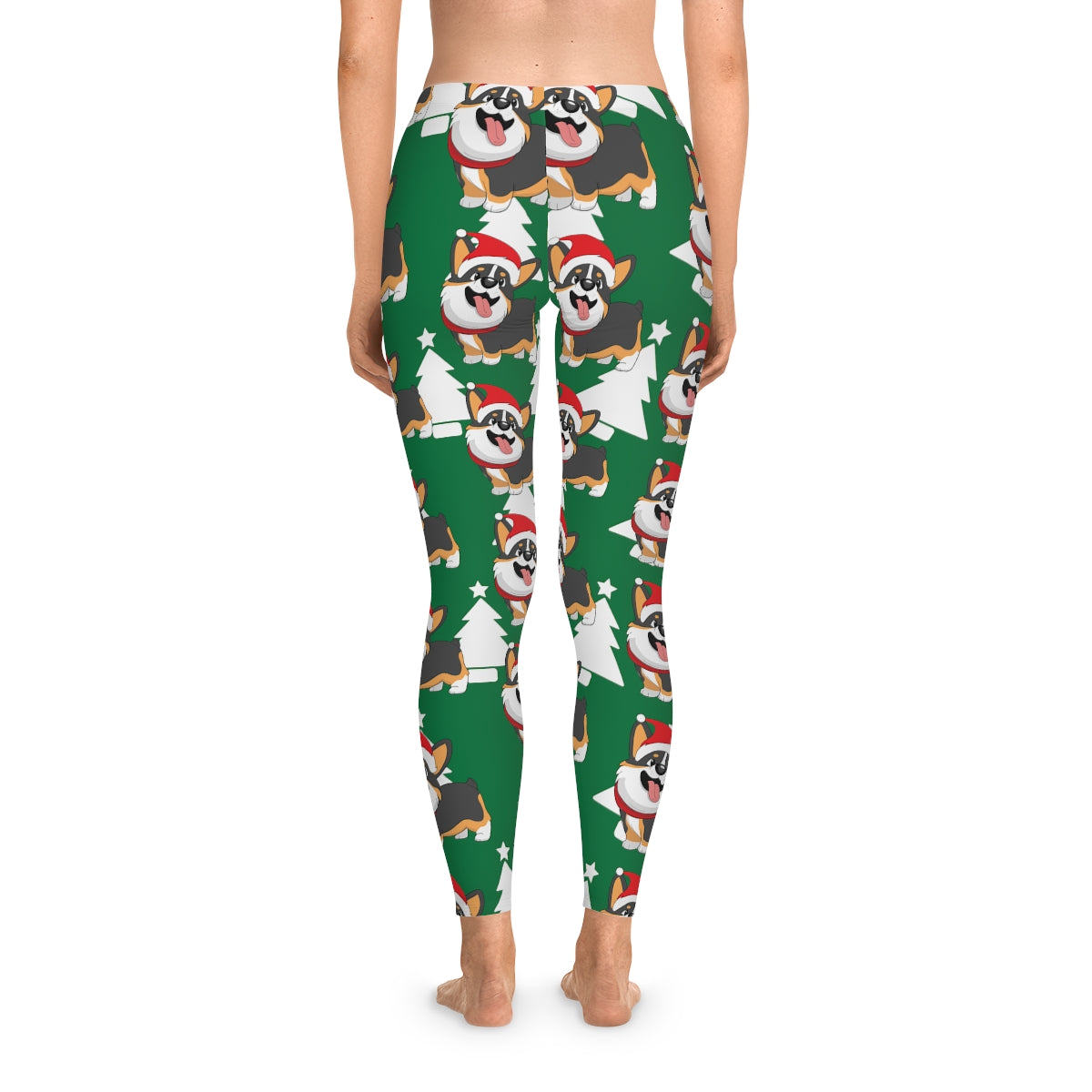 A model wearing a green pair of leggings. The pattern on the leggings is a white Christmas trees and a tricolor corgi wearing a Santa hat.