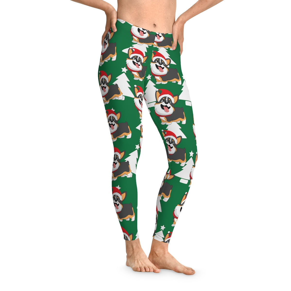 A model wearing a green pair of leggings. The pattern on the leggings is a white Christmas trees and a tricolor corgi wearing a Santa hat.