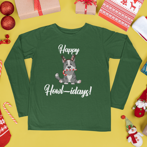 A green long sleeved shirt that has a cardigan corgi on it. The corgi is wearing fake reindeer horns and is holding a candy cane in its mouth. The text says 