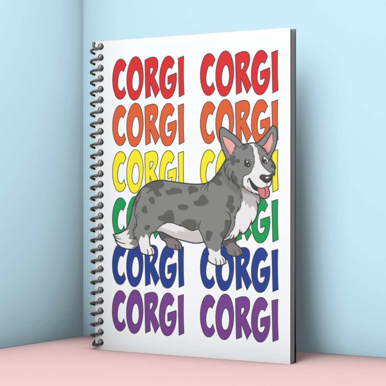 The image is of a black, spiralbound notebook leaning against a corner. The design on the cover is of a grey, dappled cardigan corgi. Behind the corgi is text that repeats the word "corgi" from top to bottom. The text is in a rainbow, with the top "Corgi"s in red and the bottom in purple.