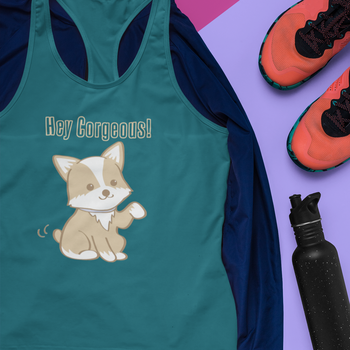 A racerback tank top with the text "Hey Corgeous" with a picture of a corgi waving. The tank top is turquoise and is laying on top of a dark blue hoodie, next to a pair of running shoes and a water bottle.