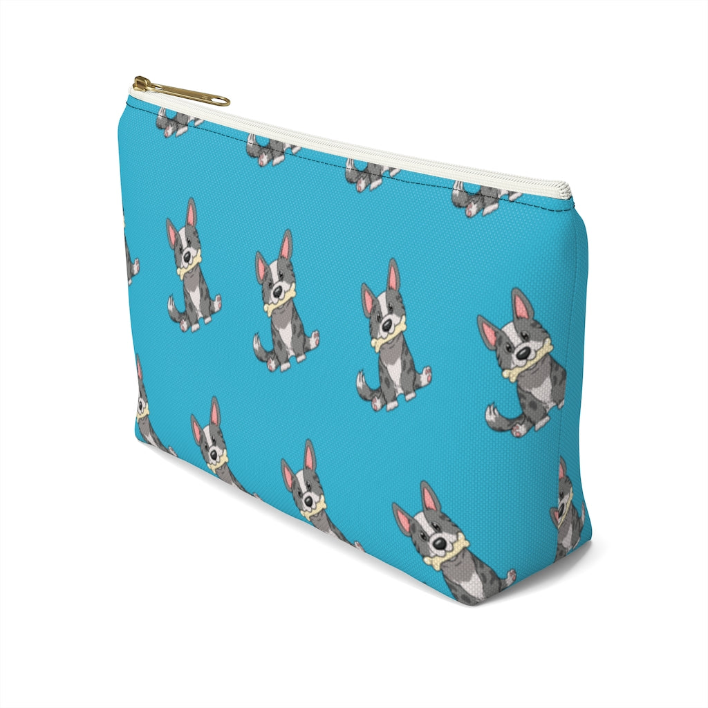 Blue make up bag with a pattern of a cardigan corgi holding a bone in its mouth, view from the side