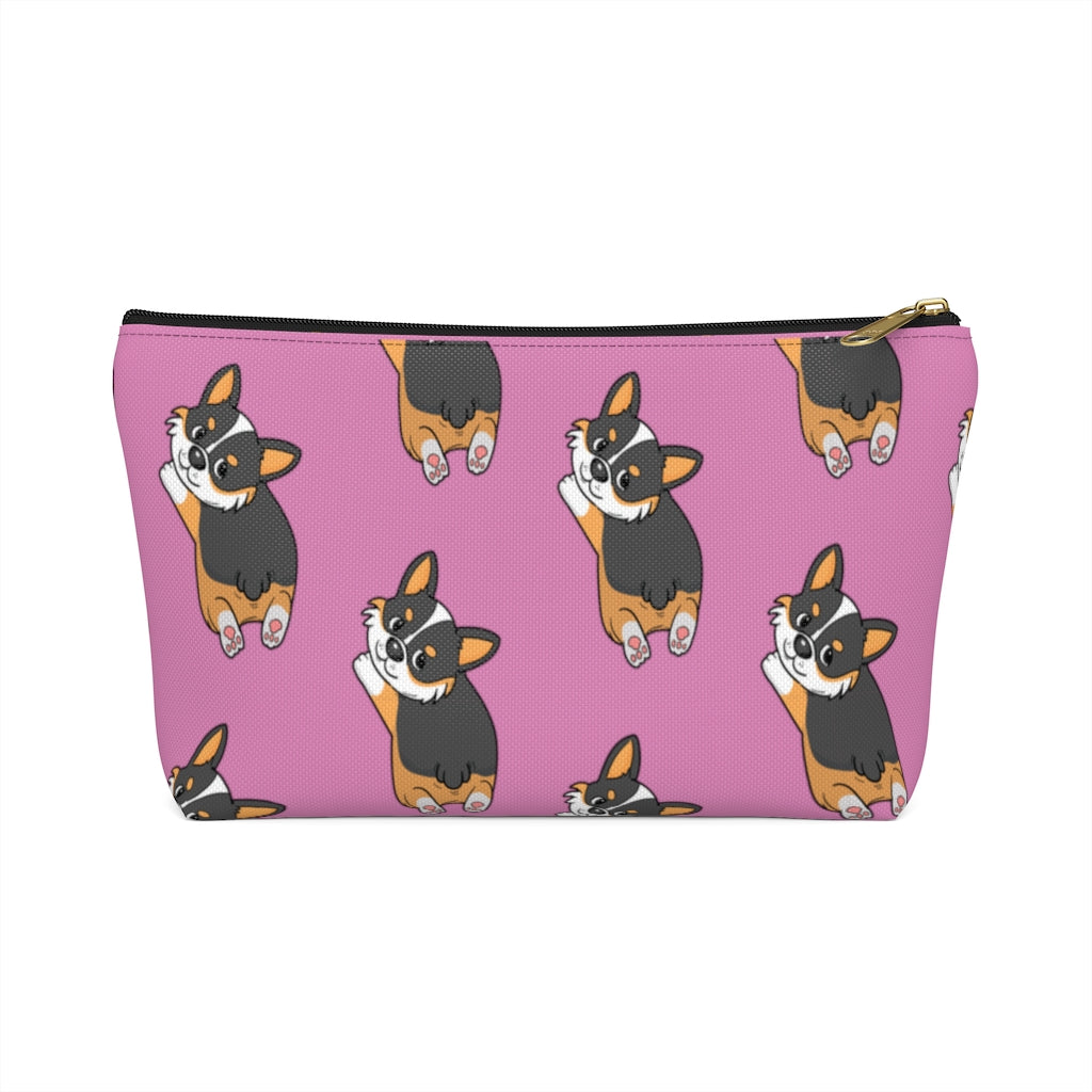 A pink make up bag with a pattern of a tricolor corgi splooting.