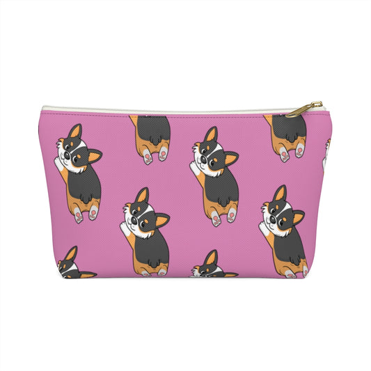 A pink make up bag with a pattern of a tricolor corgi splooting.