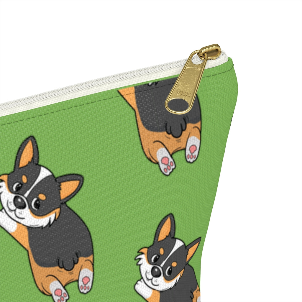 A green make up bag with a pattern of a tricolor corgi splooting.