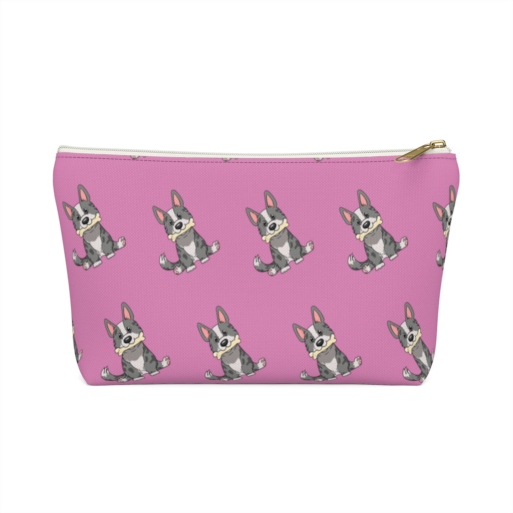 Pink make up bag with a pattern of a cardigan corgi holding a bone in its mouth, view from the side