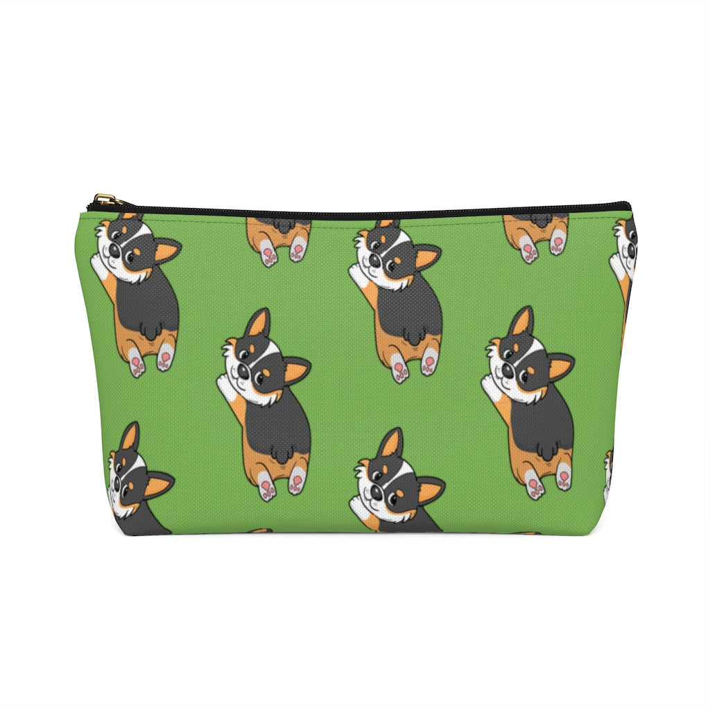 A green make up bag with a pattern of a tricolor corgi splooting.