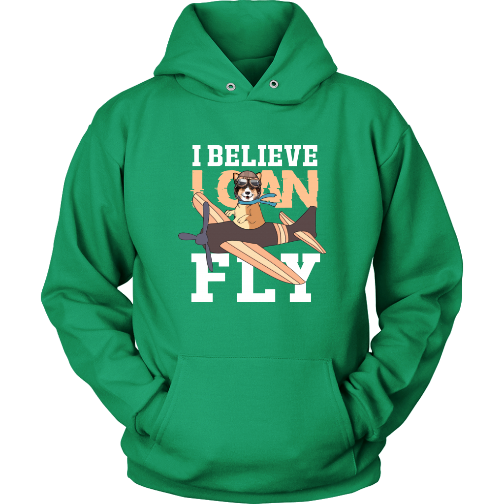 A flat lay of a green hoodie that has a corgi flying a play with the text "I believe I can fly". 