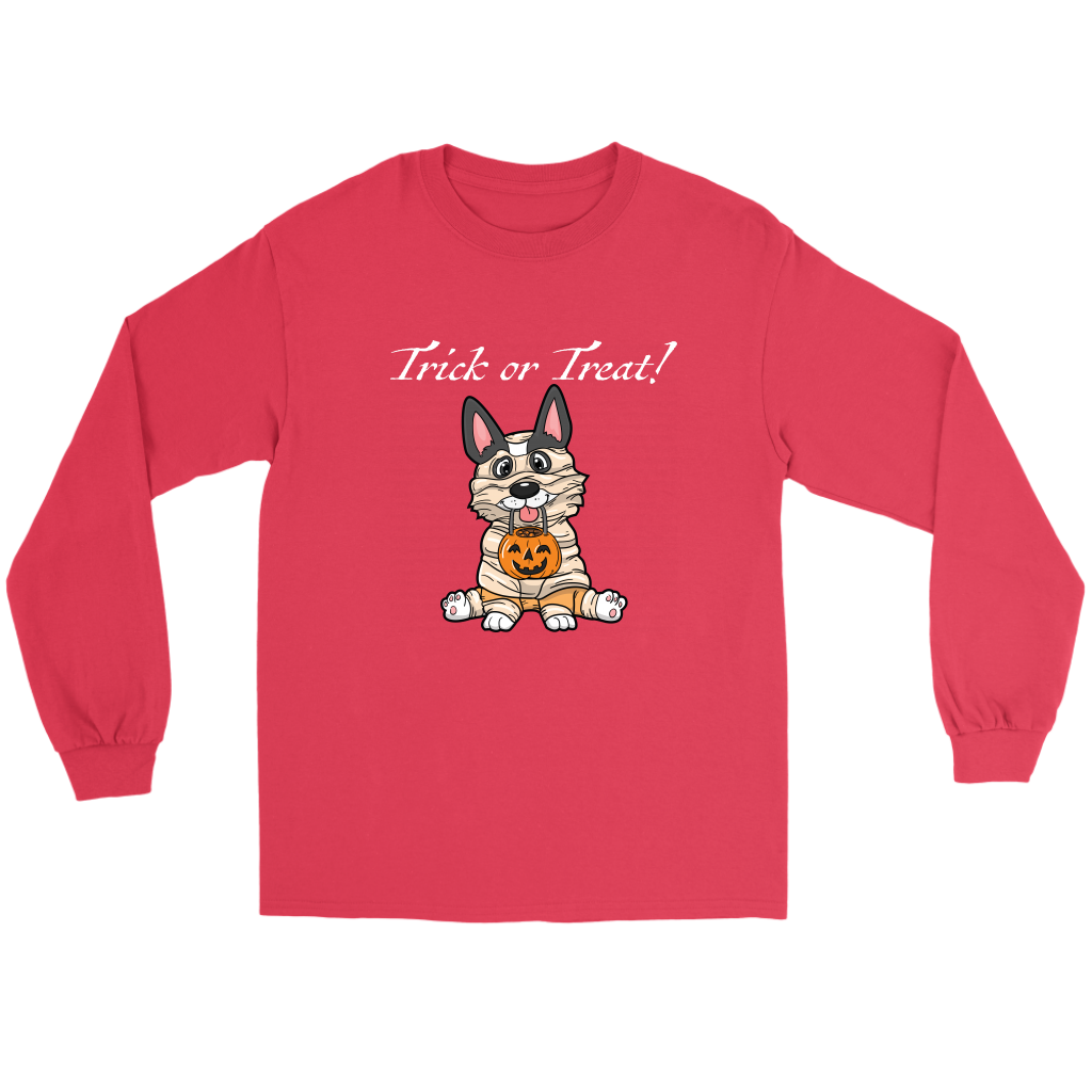 A flat lay of a red, long sleeved t shirt. The design of the shirt is a tricolor corgi dressed up as a mummy, and is holding a pumpkin trick or treat container. The text above the dog is white and says "Trick or Treat!"