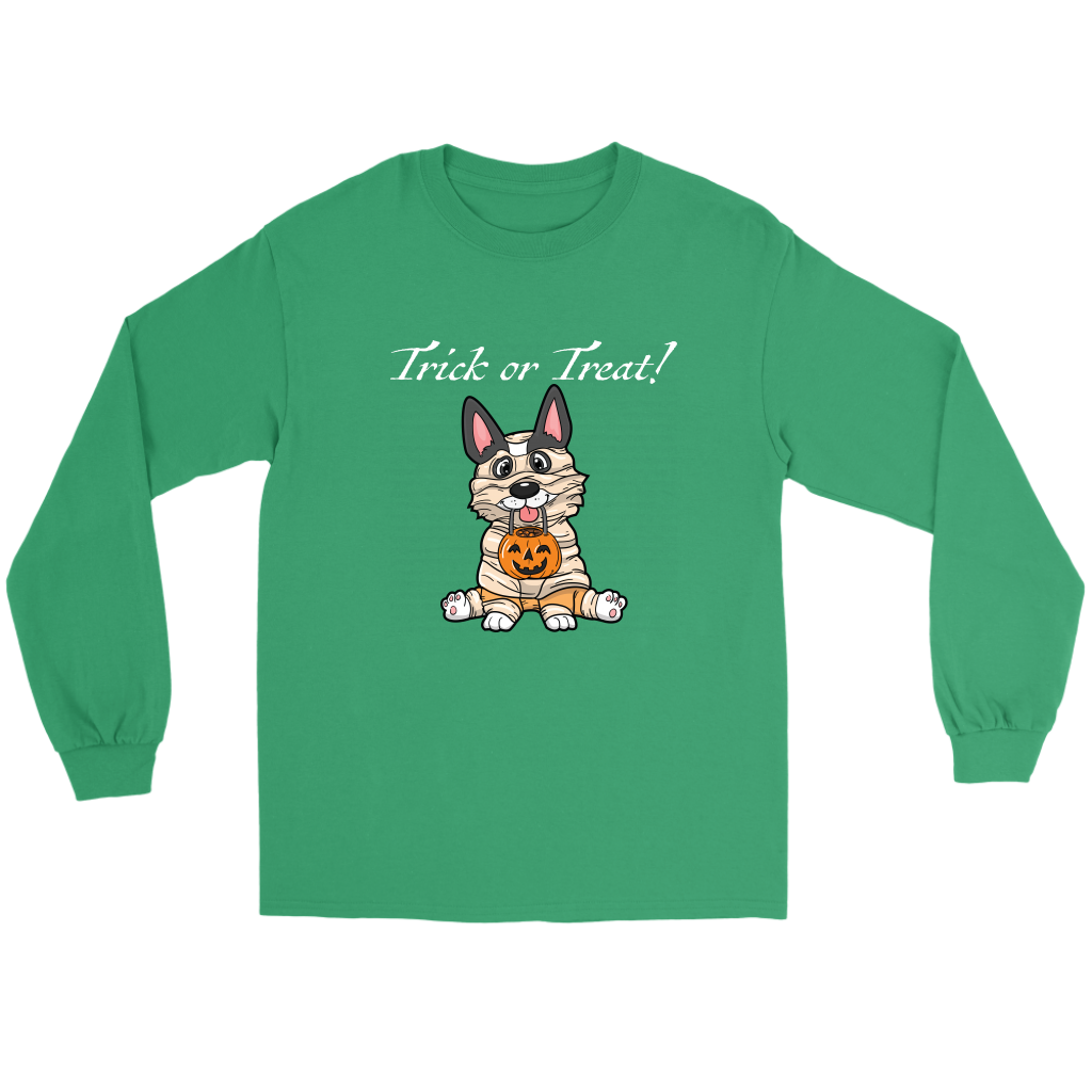 A flat lay of a green, long sleeved t shirt. The design of the shirt is a tricolor corgi dressed up as a mummy, and is holding a pumpkin trick or treat container. The text above the dog is white and says "Trick or Treat!"