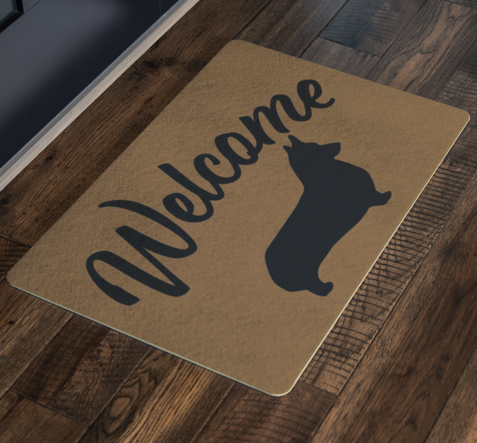 A doormat with the text "Welcome" with a silhouette of a corgi under to it in front of a door.