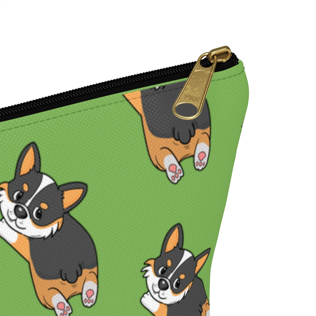 A green make up bag with a pattern of a tricolor corgi splooting.