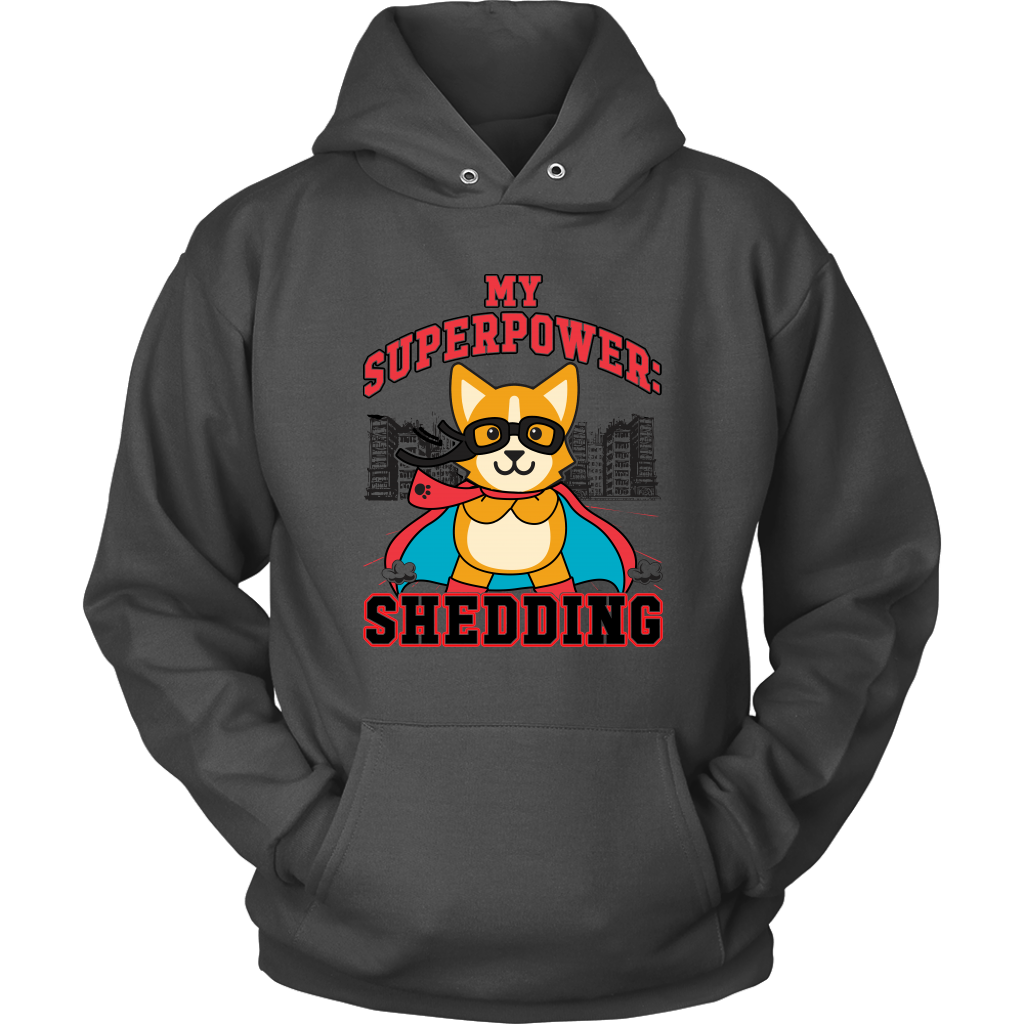 A flay lay of a hoodie that is dark grey and has red and black text that says "My superpower: Shedding" with a corgi dressed as a superhero. 