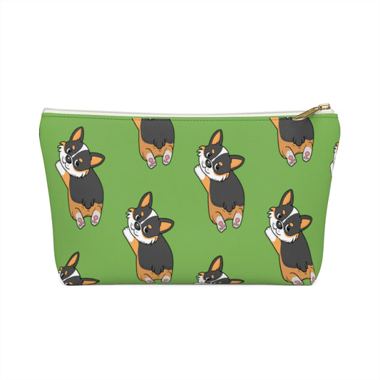 A green make up bag with a pattern of a tricolor corgi splooting.