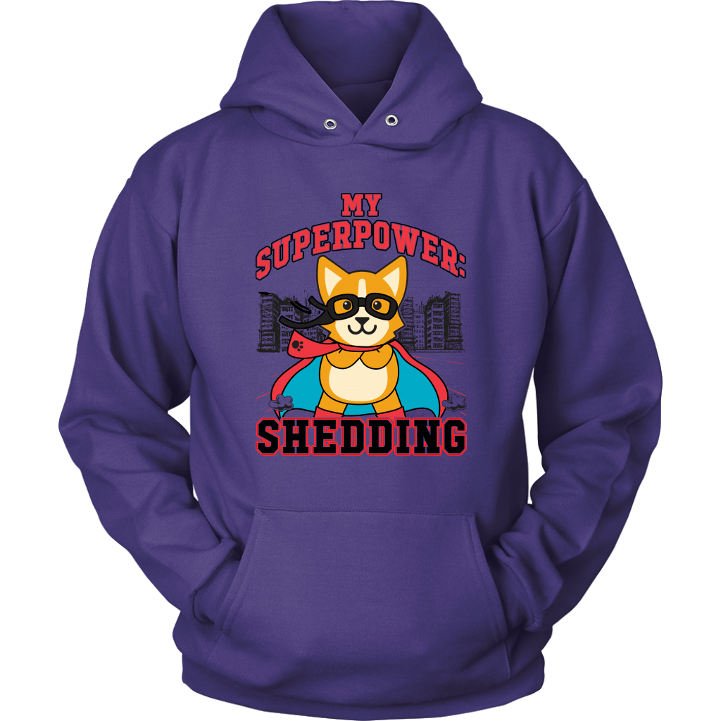 A flay lay of a hoodie that is dark blue and has red and black text that says "My superpower: Shedding" with a corgi dressed as a superhero. 