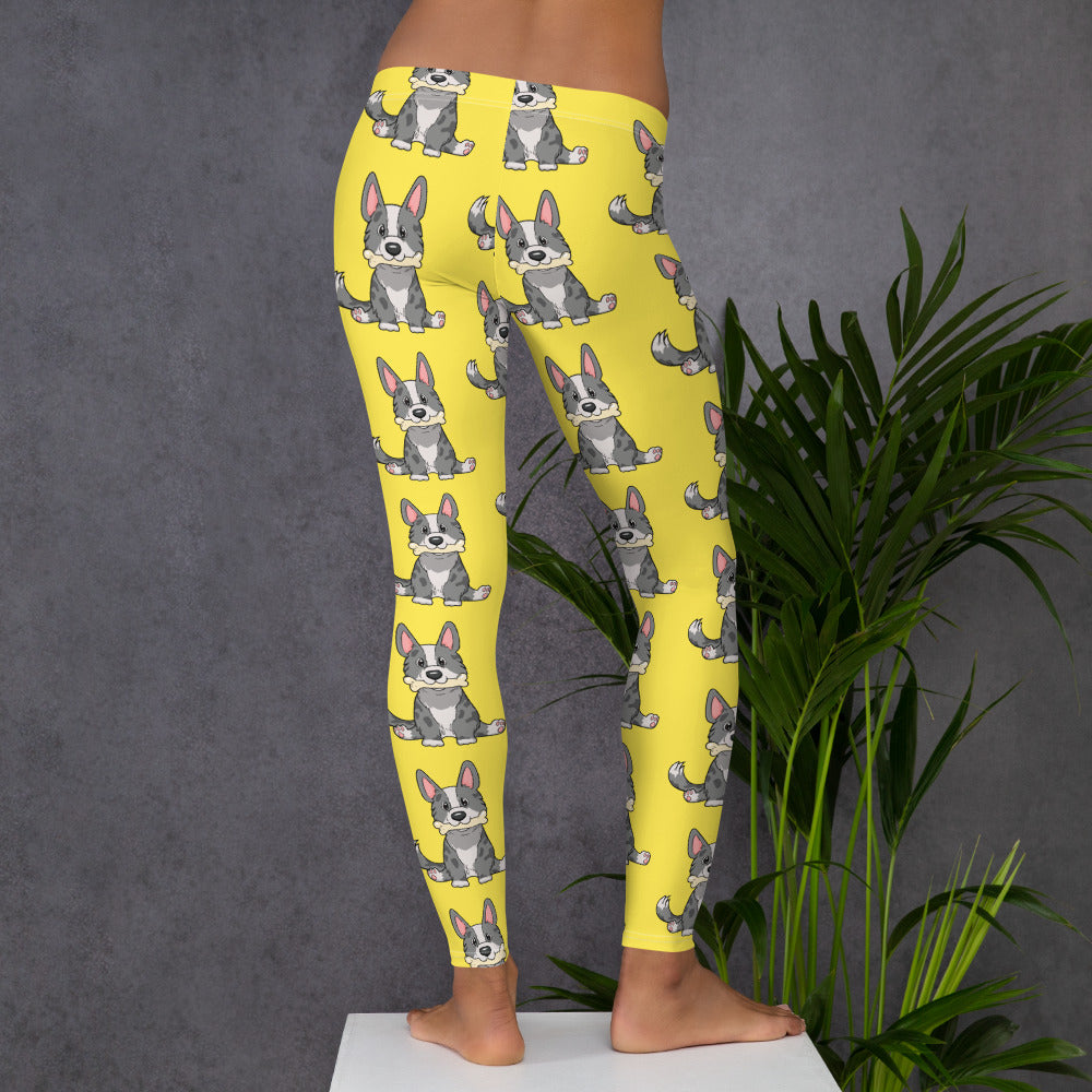 Yellow leggings with a pattern of a cardigan corgi holding a bone in its mouth, from the back