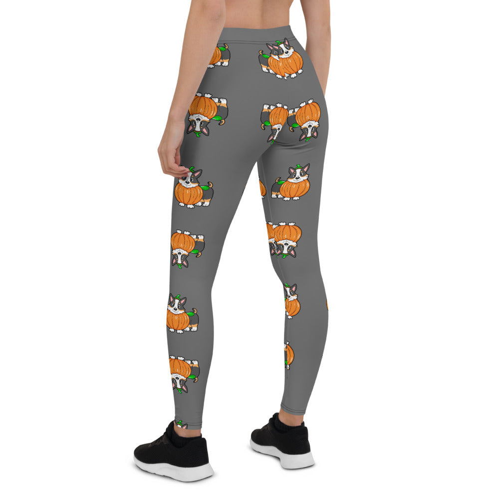 A woman modeling our pumpkin Tricolor Halloween Leggings. The pattern is a tricolor corgi wearing a pumpkin costume.