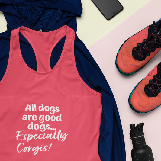 A flat lay of a racerback tank top laying on top of a dark blue hoodie. The clothes are laying next to a cell phone, running shoes, and a water bottle. The text on the shirt says: "All dogs are good dogs, especially corgis!" and the tank top is red.