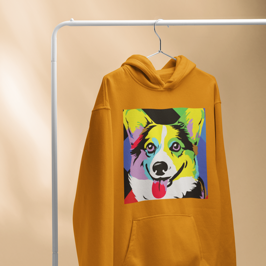 Our pop art corgi design on an orange hoodie. The hoodie is hanging from a hanger on a clothing rack. 