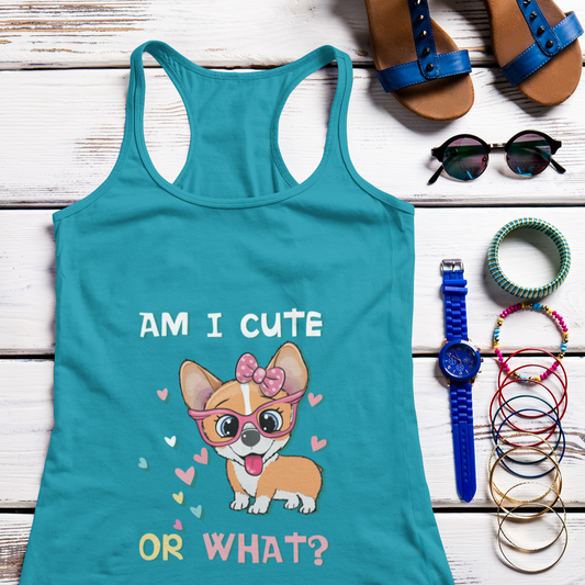 A racerback tank top laying on a table with some bracelets, sunglasses, a watch, and some sandals. The tank top has the text "AM I CUTE OR WHAT?" with a cartoon corgi wearing glasses and a bow. The tank top is teal colored. 