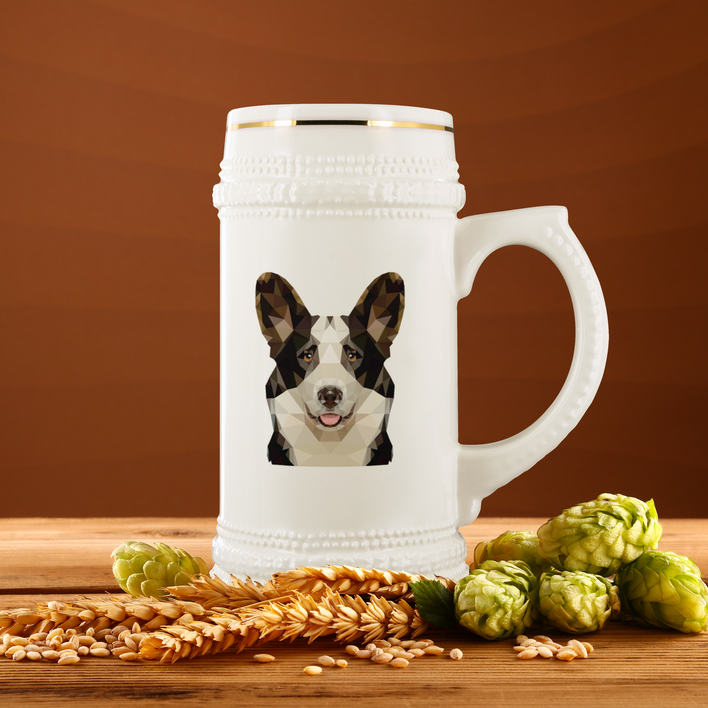 Beer stein with a polygonal cardigan corgi on it, sitting on a table with some hops and wheat