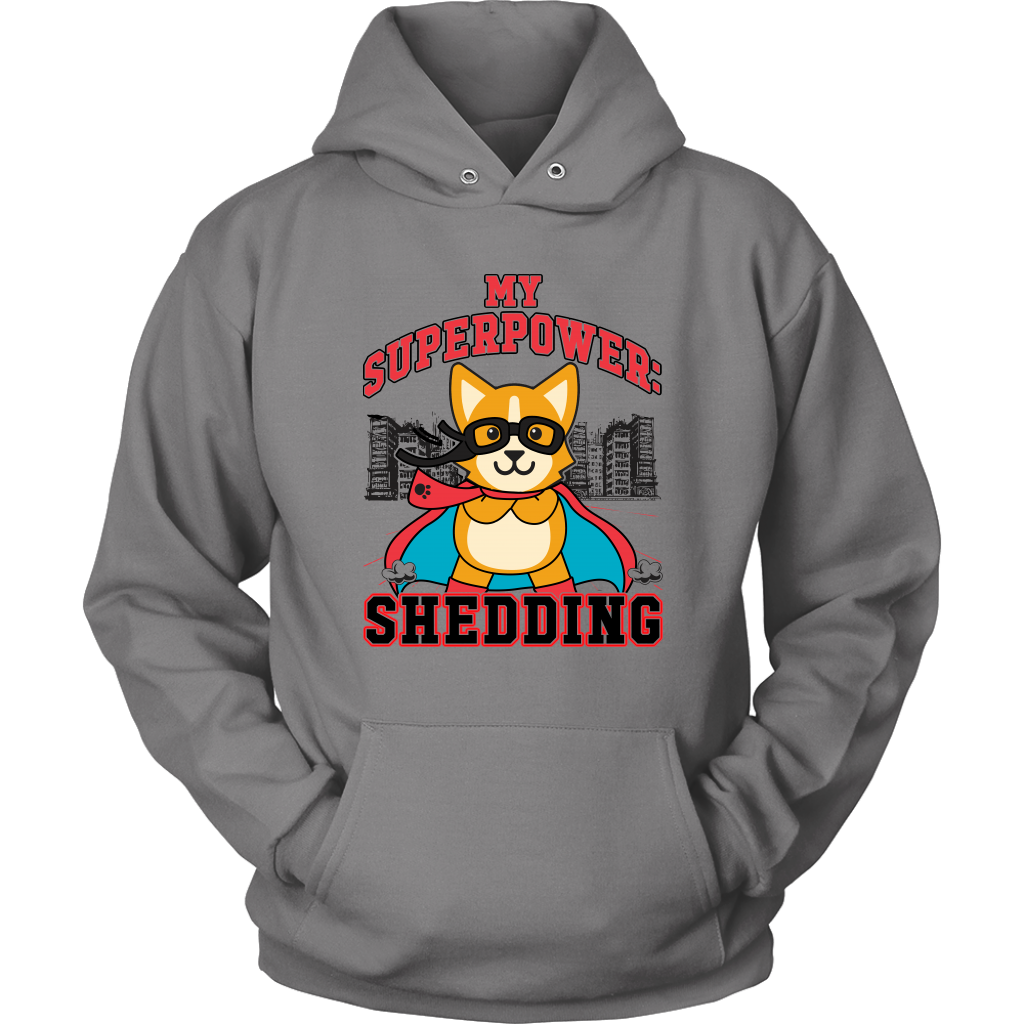 A flay lay of a hoodie that is grey and has red and black text that says "My superpower: Shedding" with a corgi dressed as a superhero. 