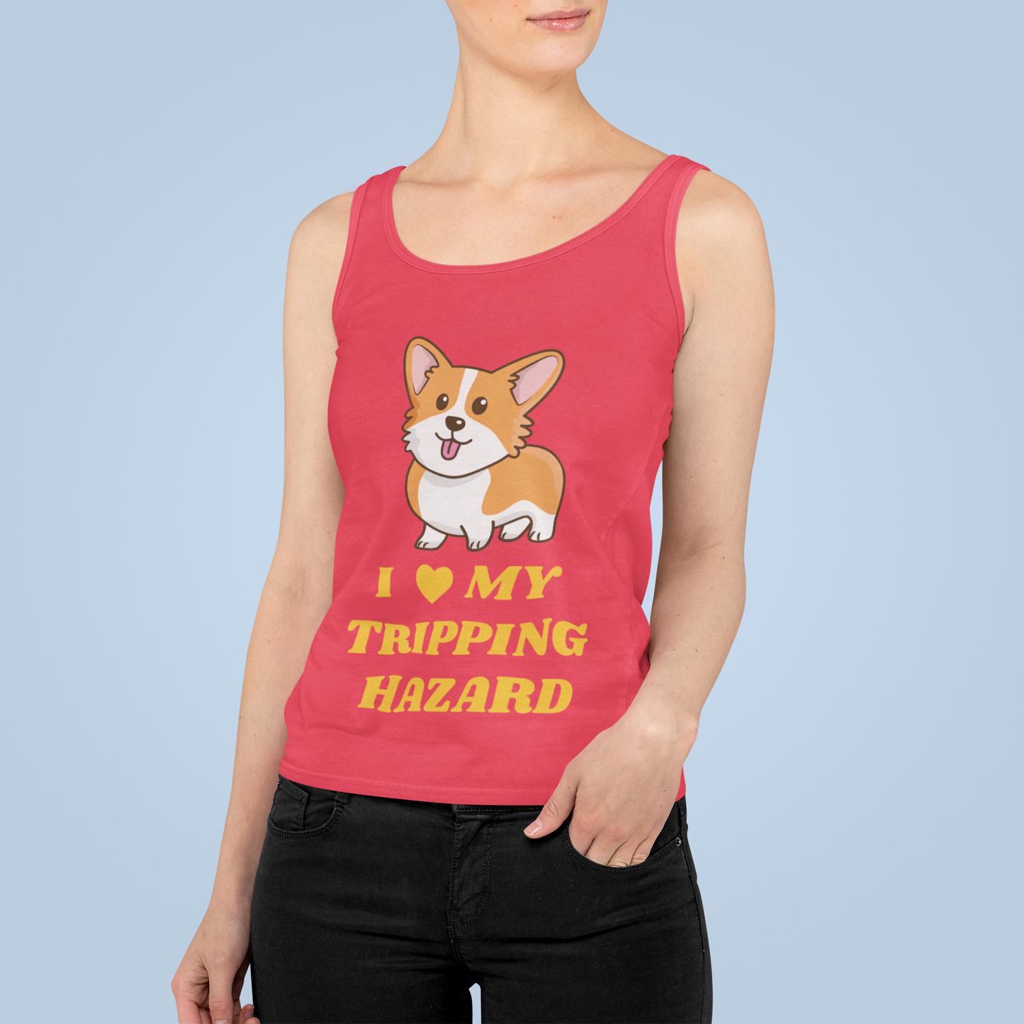 A model wearing a racerback tank top with the text "I love my tripping hazard" with a picture of a corgi. The tank top is red.